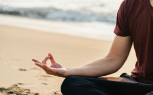 man meditating on the beach